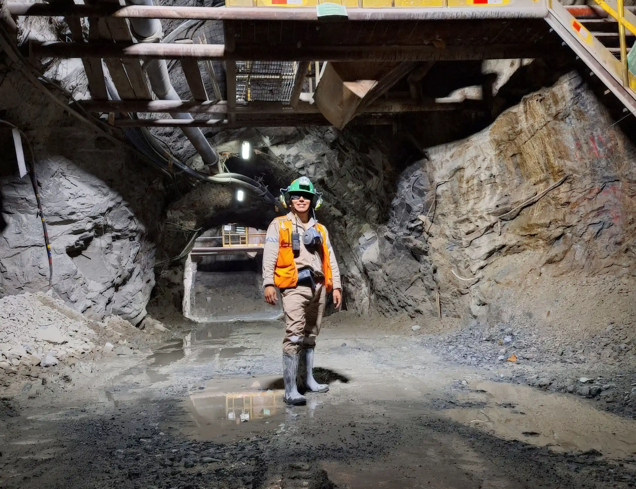 A geologist in safety gear in an underground mine tunnel